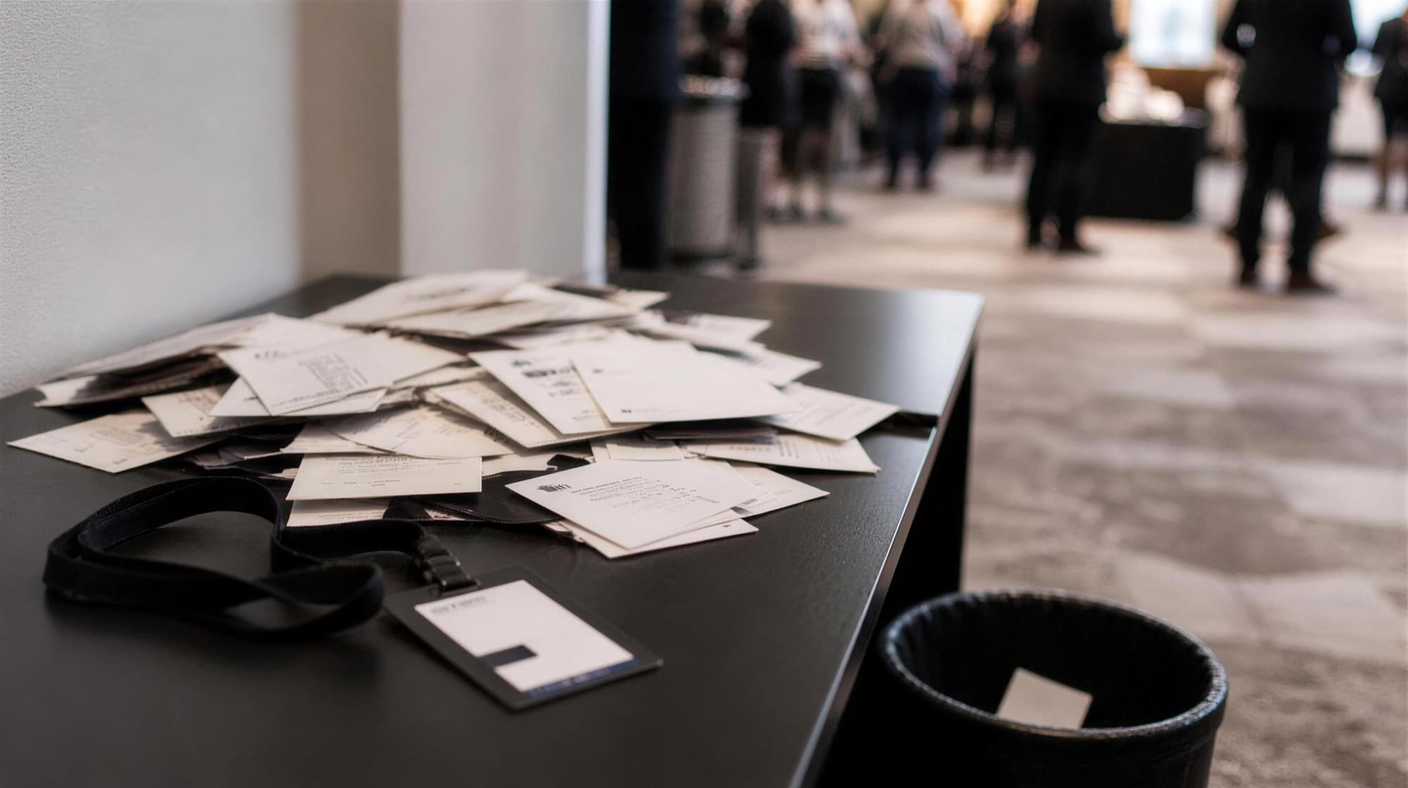 A pile of forgotten paper business cards left behind at a conference